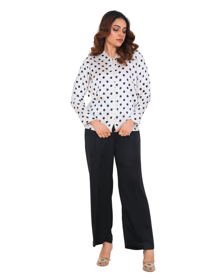"Model wearing a polka dot silk co-ord set with a white shirt and black trousers – Emeralds summer collection"