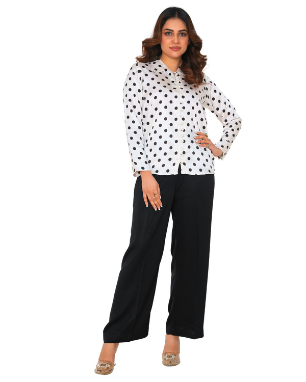 "Model wearing a polka dot silk co-ord set with a white shirt and black trousers – Emeralds summer collection"