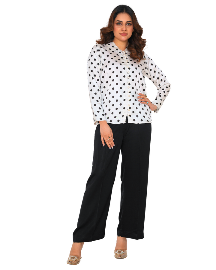 "Model wearing a polka dot silk co-ord set with a white shirt and black trousers – Emeralds summer collection"