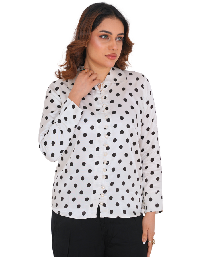 "Model wearing a polka dot silk co-ord set with a white shirt and black trousers – Emeralds summer collection"