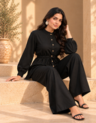 Model seated in ONYX black Khaddi co-ord set with relaxed shirt and flowing wide-leg pants