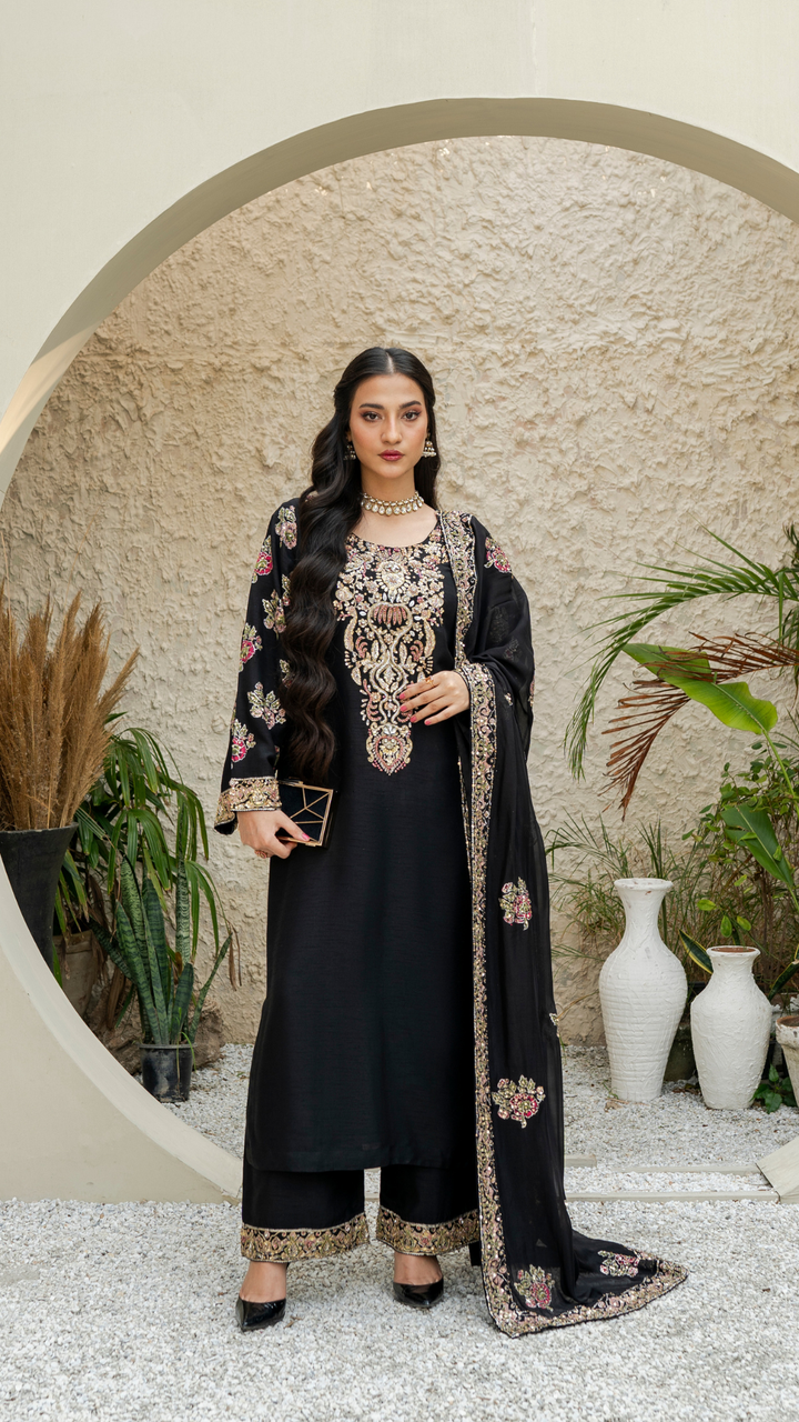 Model wearing a black 3-piece embellished raw silk outfit with embroidered dupatta from Emeralds’ luxury collection